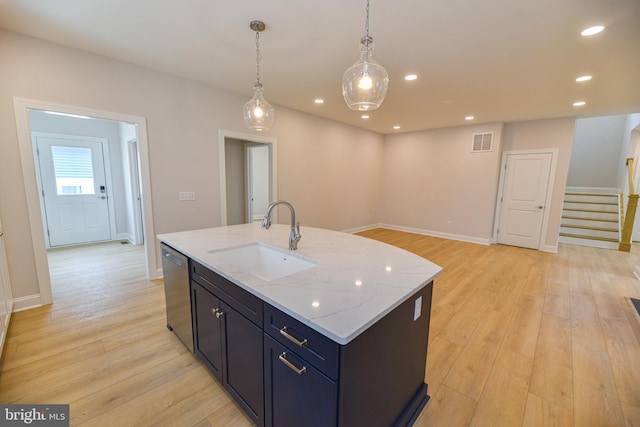 kitchen with sink, pendant lighting, light hardwood / wood-style flooring, dishwasher, and an island with sink