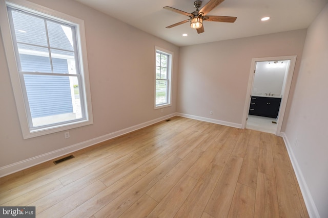 unfurnished bedroom featuring light hardwood / wood-style flooring, ensuite bath, and ceiling fan