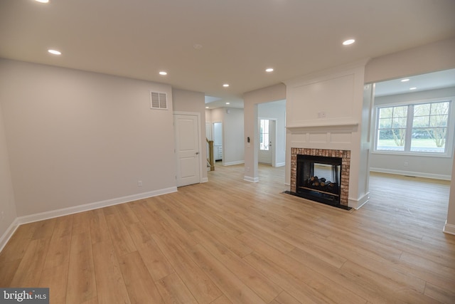 unfurnished living room featuring light hardwood / wood-style floors and a fireplace