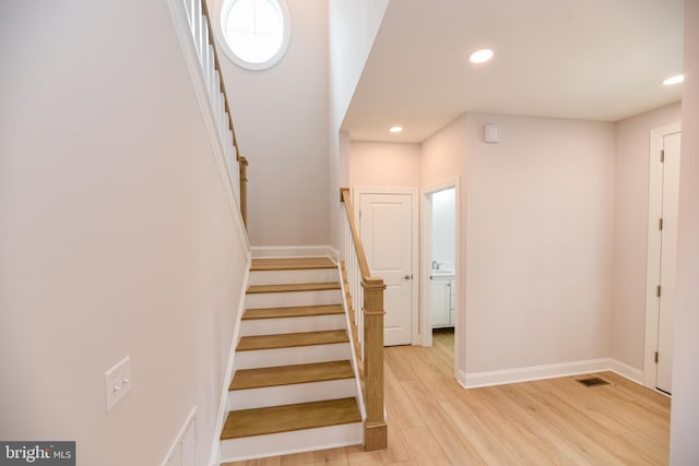 stairs featuring hardwood / wood-style floors