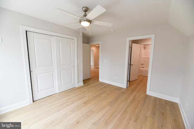 unfurnished bedroom featuring ceiling fan, light hardwood / wood-style floors, lofted ceiling, and a closet