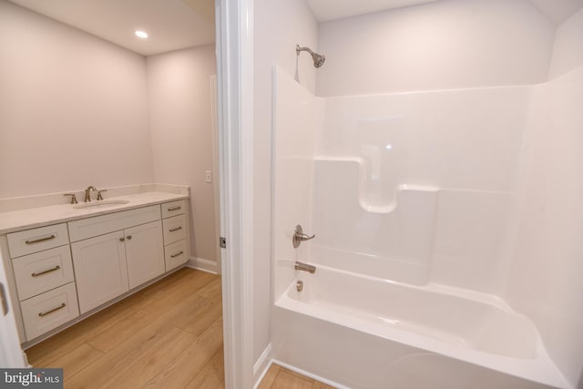 bathroom with hardwood / wood-style floors, vanity, and  shower combination