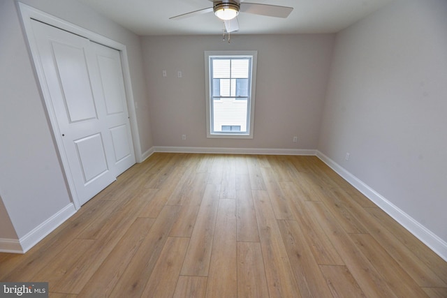 unfurnished bedroom with light wood-type flooring, a closet, and ceiling fan