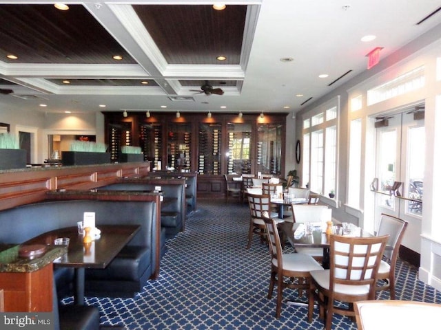 carpeted dining space featuring ceiling fan, beamed ceiling, coffered ceiling, and ornamental molding