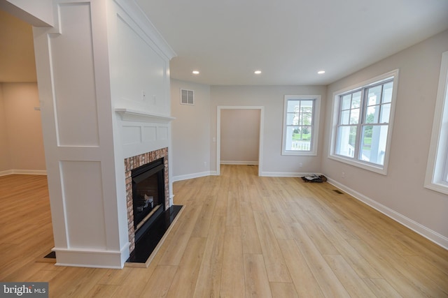 unfurnished living room featuring light hardwood / wood-style floors and a fireplace