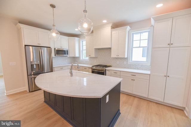 kitchen featuring light hardwood / wood-style flooring, backsplash, pendant lighting, white cabinets, and appliances with stainless steel finishes