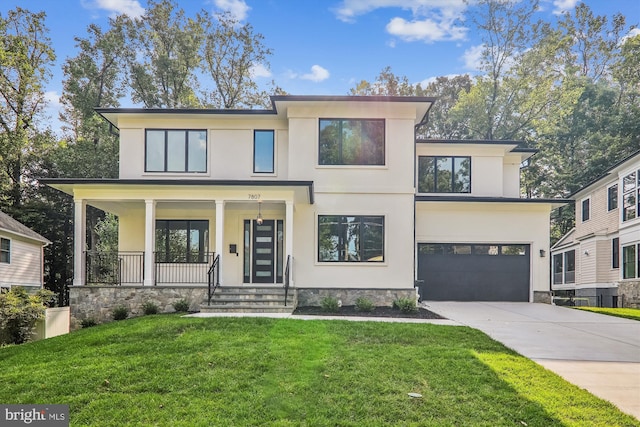 view of front facade with stucco siding, covered porch, an attached garage, a front yard, and driveway