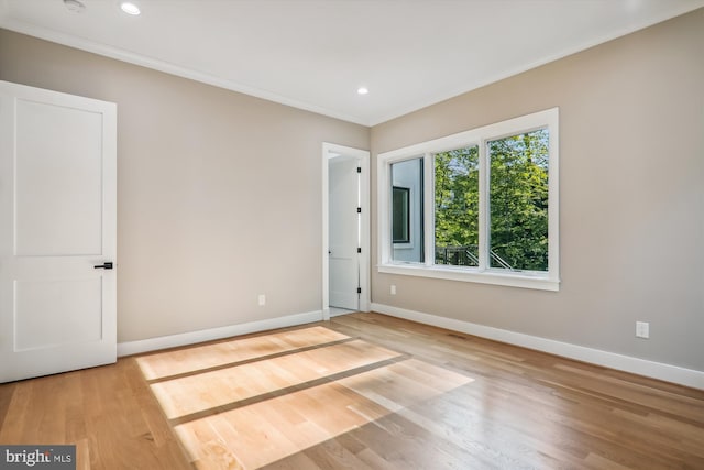 unfurnished room with crown molding, baseboards, and wood finished floors