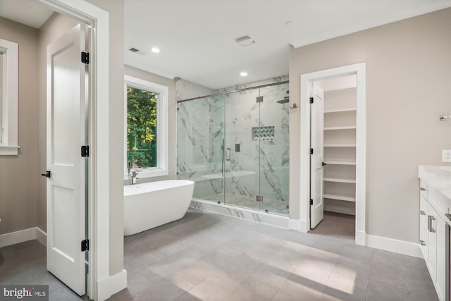 full bath with a marble finish shower, visible vents, baseboards, a soaking tub, and vanity