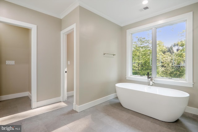 bathroom with baseboards, visible vents, a freestanding bath, and ornamental molding