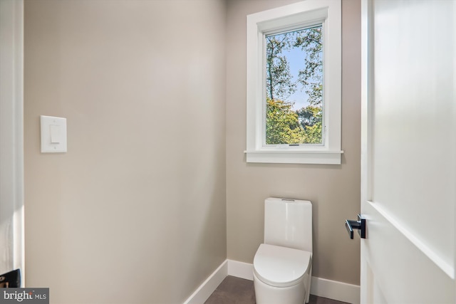 bathroom with toilet and baseboards