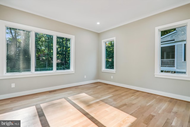 unfurnished room with recessed lighting, crown molding, baseboards, and wood finished floors