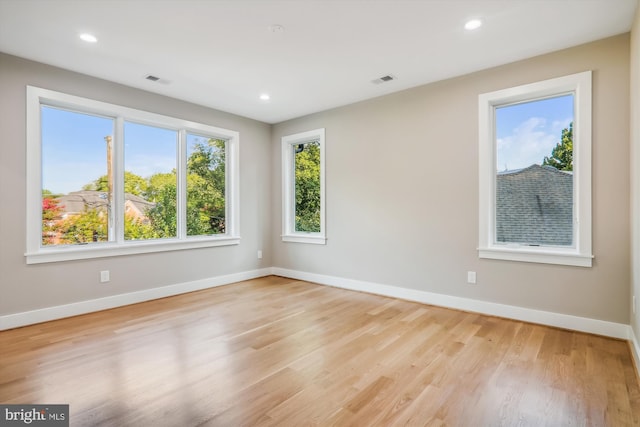 empty room with recessed lighting, visible vents, light wood finished floors, and baseboards