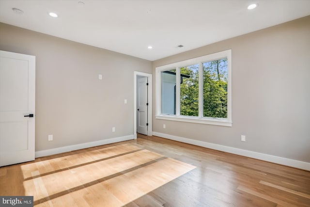 empty room featuring baseboards, wood finished floors, and recessed lighting