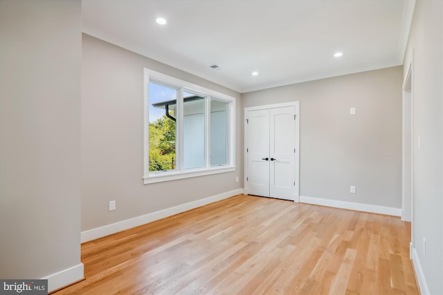 unfurnished room with recessed lighting, visible vents, light wood-style floors, baseboards, and ornamental molding