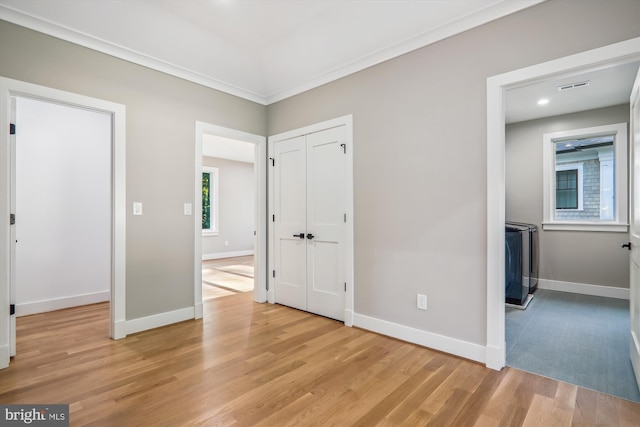 unfurnished bedroom with light wood finished floors, visible vents, and baseboards