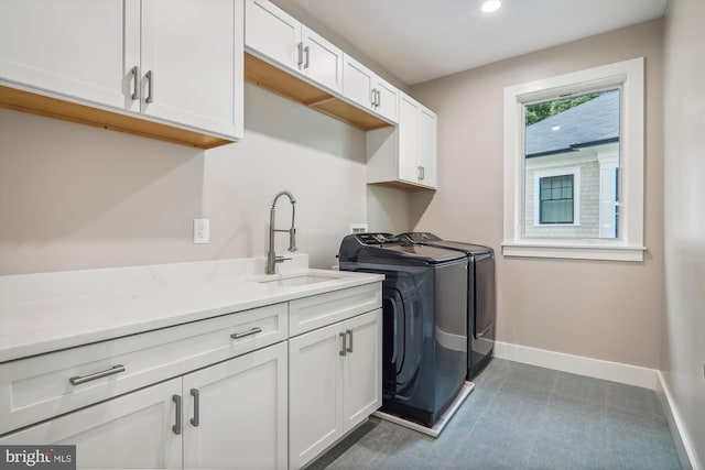 laundry room featuring recessed lighting, cabinet space, a sink, separate washer and dryer, and baseboards