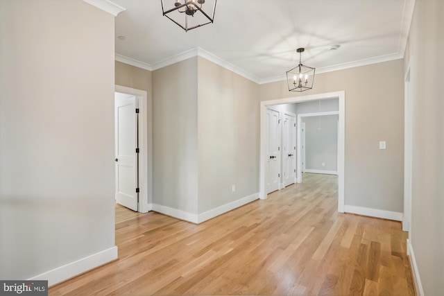 interior space with baseboards, light wood-type flooring, a notable chandelier, and crown molding