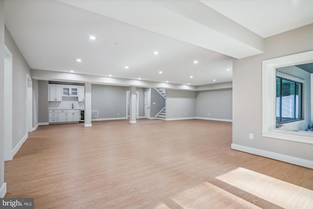 basement with baseboards, visible vents, stairway, light wood-type flooring, and recessed lighting