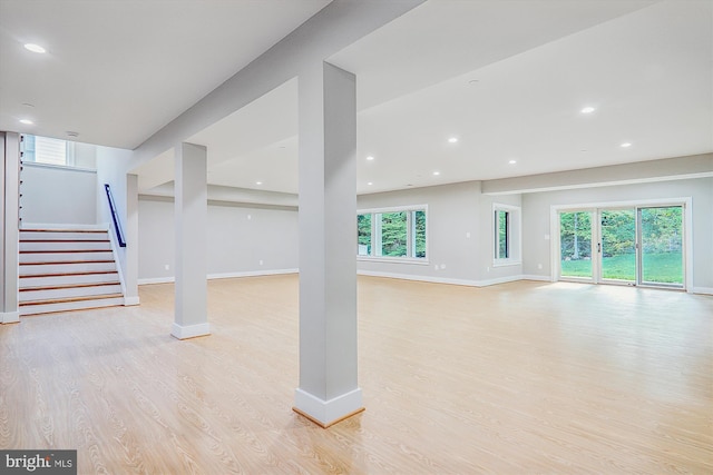 basement featuring light wood-style flooring, stairs, baseboards, and recessed lighting