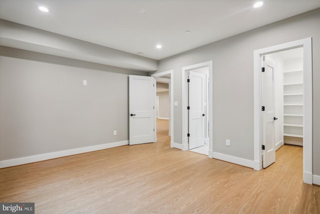 unfurnished bedroom featuring light wood-type flooring, baseboards, and recessed lighting