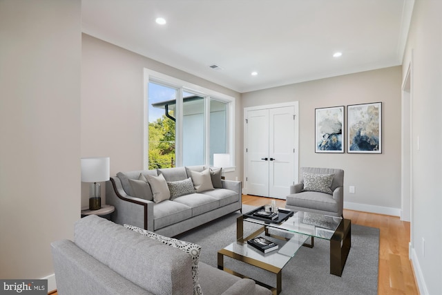 living area with crown molding, recessed lighting, visible vents, wood finished floors, and baseboards