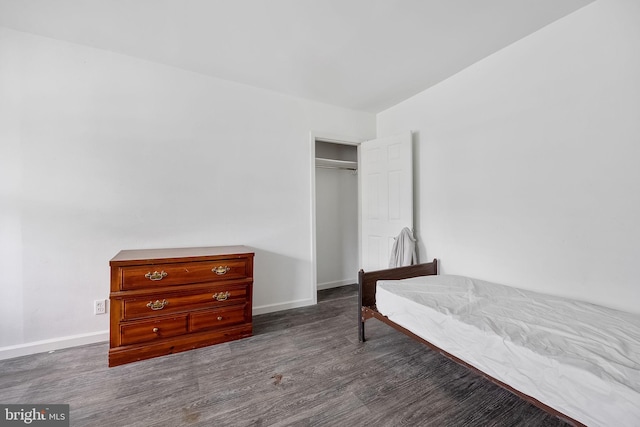 bedroom with dark hardwood / wood-style flooring and a closet