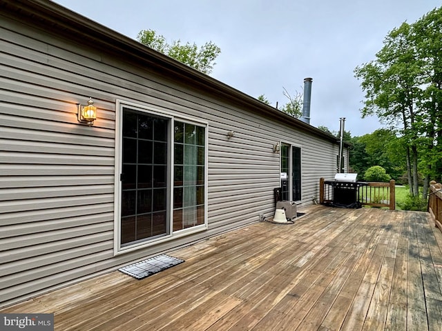 wooden deck featuring a grill