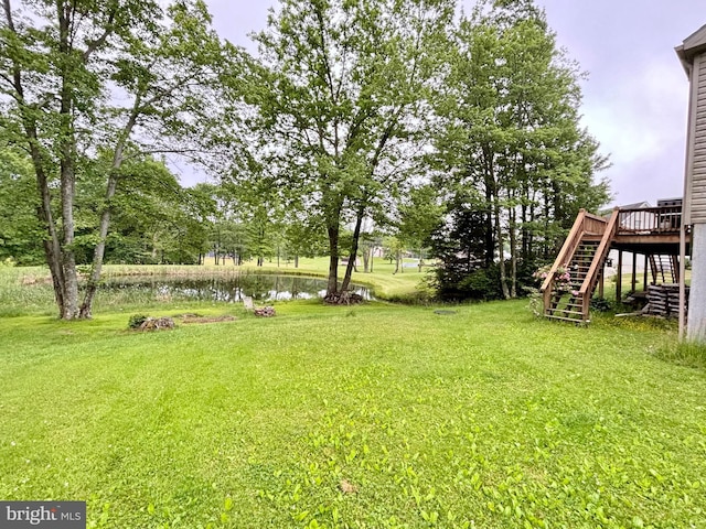 view of yard with a deck with water view