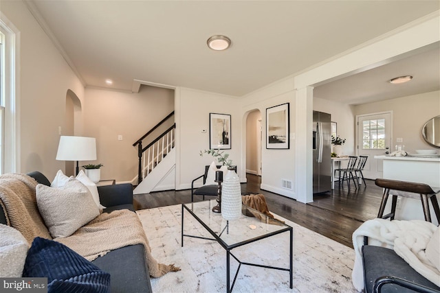 living room with dark hardwood / wood-style floors and crown molding