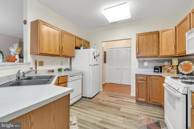 kitchen featuring decorative backsplash, light wood-type flooring, white appliances, and sink