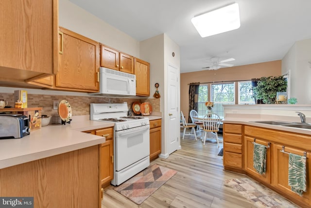 kitchen featuring white appliances, sink, ceiling fan, light wood-type flooring, and tasteful backsplash