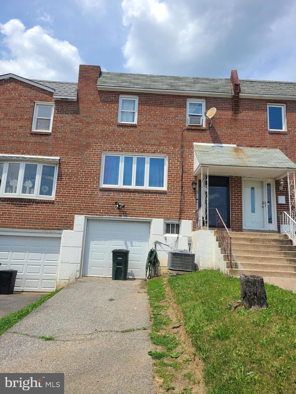 view of front of home with a garage and central air condition unit