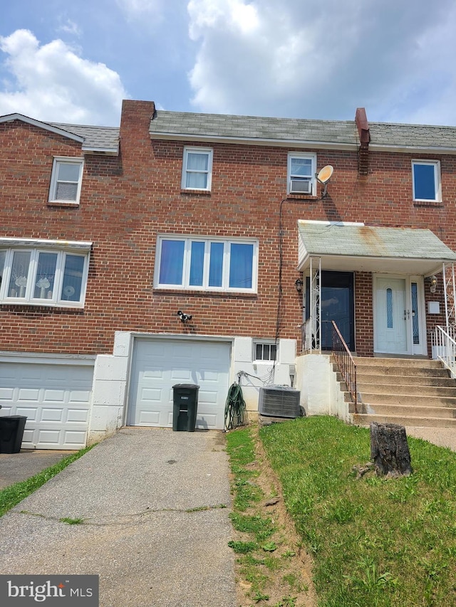 view of front of home with a garage and central air condition unit