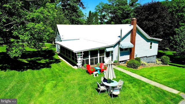 view of front facade with a sunroom and a front lawn