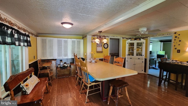 dining space with dark hardwood / wood-style floors, crown molding, ceiling fan with notable chandelier, and a wealth of natural light