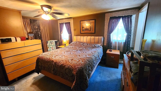 carpeted bedroom with a textured ceiling, ceiling fan, a baseboard heating unit, and ornamental molding