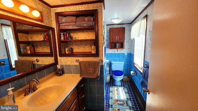 bathroom with vanity, toilet, tile walls, and crown molding