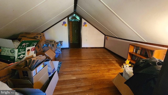 additional living space featuring wood-type flooring and vaulted ceiling