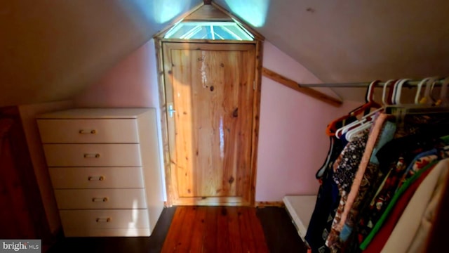 spacious closet with dark hardwood / wood-style floors and lofted ceiling