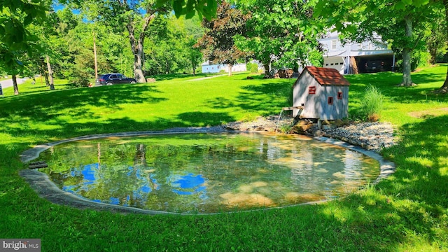 surrounding community featuring a yard and a garden pond