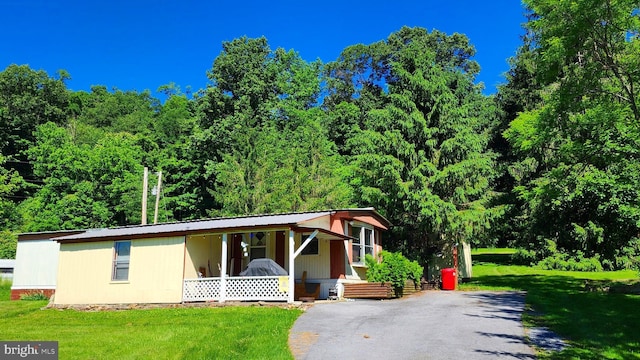 view of front of home with covered porch and a front lawn