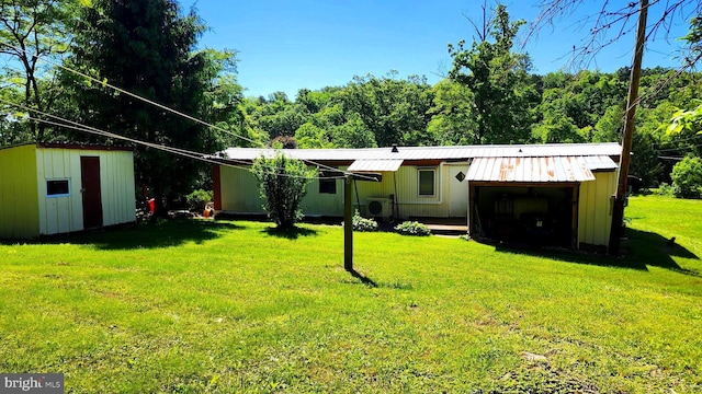 rear view of property with a yard and a shed