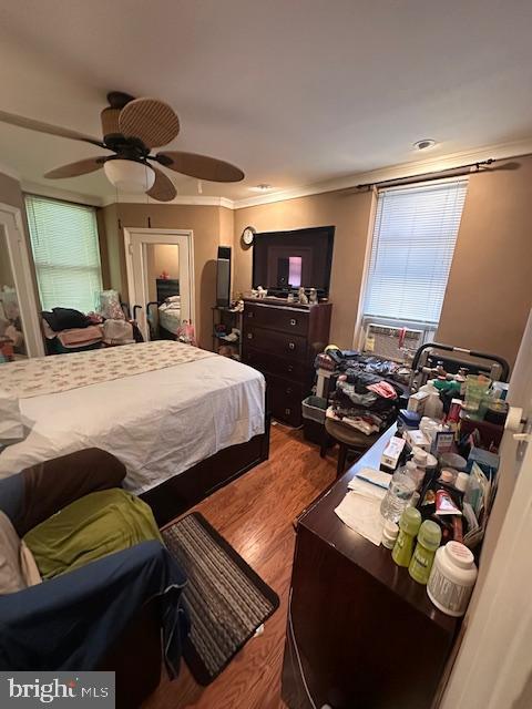 bedroom with ceiling fan, ornamental molding, and hardwood / wood-style flooring