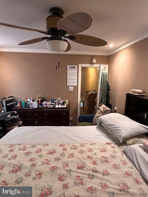 bedroom featuring ceiling fan and ornamental molding