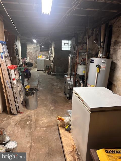 basement with water heater and fridge