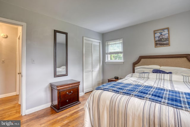 bedroom with light wood-type flooring and a closet