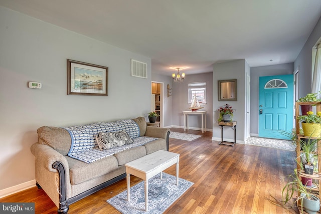 living room featuring hardwood / wood-style floors and an inviting chandelier