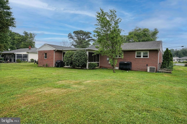 rear view of house with a yard and cooling unit