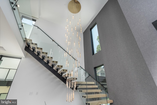 stairway featuring a towering ceiling